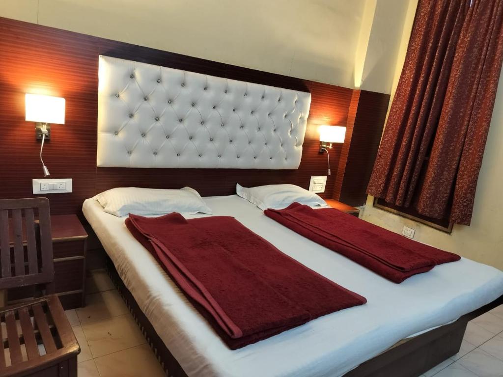a bedroom with a large bed with two red towels on it at Hotel Prince Palace (The Green) in New Delhi