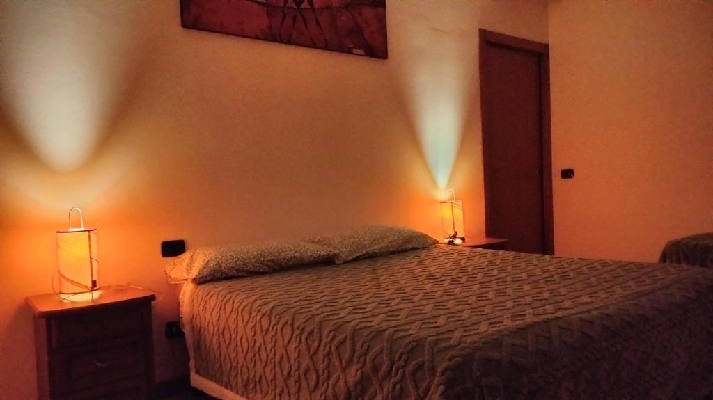 ein Schlafzimmer mit einem Bett und zwei Lampen an der Wand in der Unterkunft Le Chic 2 Vanzago in Vanzago