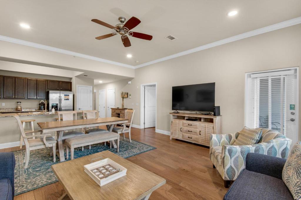 a living room with a ceiling fan and a table at Alerio B203 in Destin