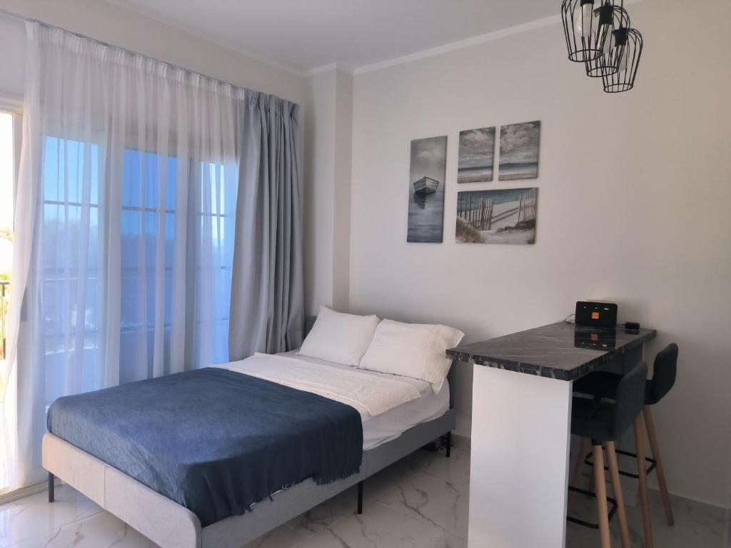 1 dormitorio con cama, escritorio y ventana en Solo beach front studio or for couple, en Hurghada