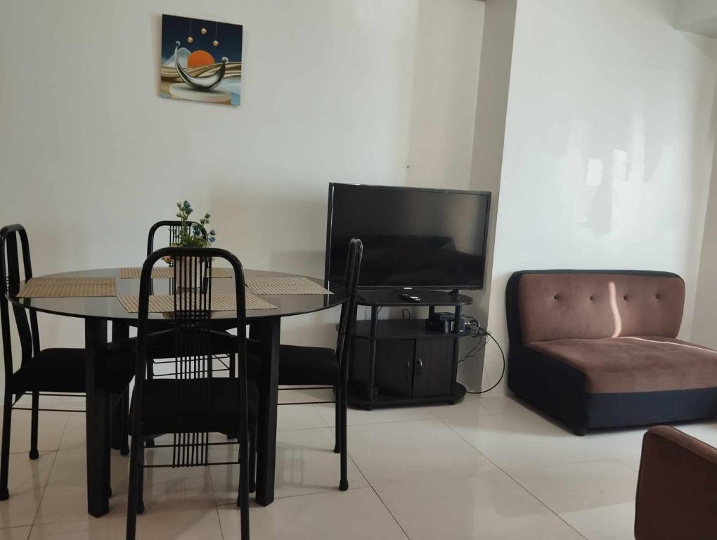 a living room with a table and a tv and a couch at Roxas Blvd Stunning Studio Condo Near US Embassy in Manila