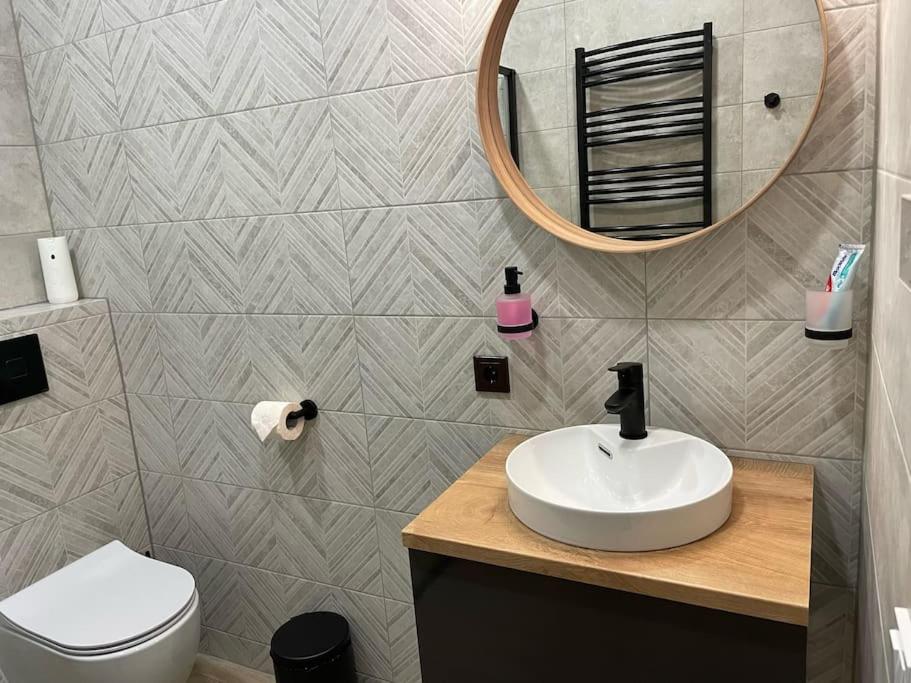 y baño con lavabo y espejo. en Modernūs apartamentai Svencelėje, en Svencelė
