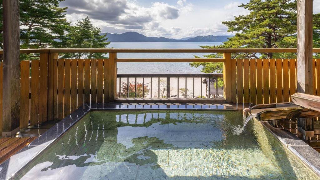 a pool on a deck with a view of the water at Katakurinohana in Senboku