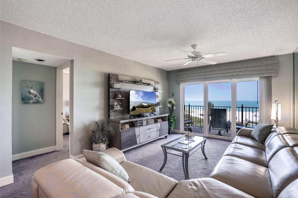 Una sala de estar con un sofá y un televisor de pantalla plana. en Land's End 6-404 Beach Front, en St Pete Beach