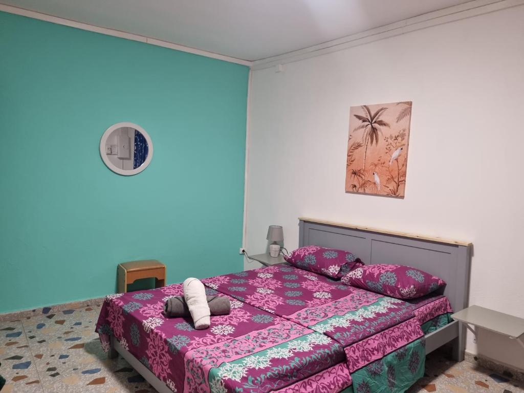 een slaapkamer met een bed met een roze sprei bij STARALOGE in Pamandzi