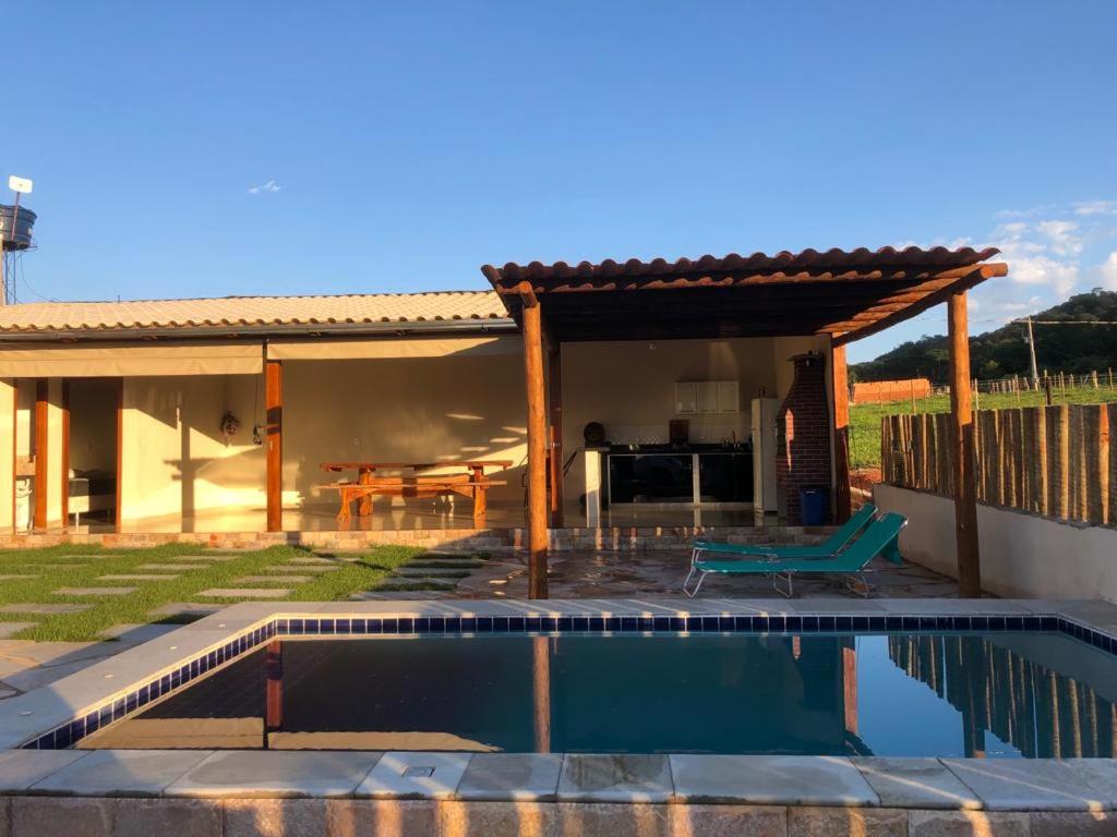 a house with a swimming pool in the yard at Chalé sossego in Pirenópolis