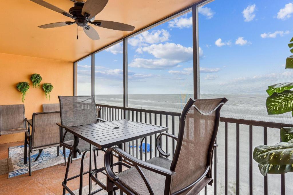 a balcony with a table and chairs and a view of the ocean at Villa Madeira 408 - Premier in St Pete Beach