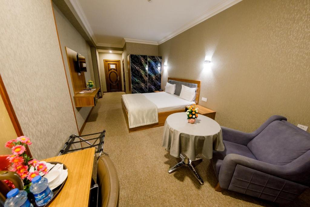 um quarto de hotel com uma cama, um sofá e uma mesa em Royal Boutique Baku em Baku