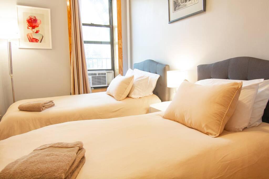 deux lits dans une chambre avec une fenêtre dans l'établissement 2 Bedroom Apt with 3 Beds - Friends & Family, à New York