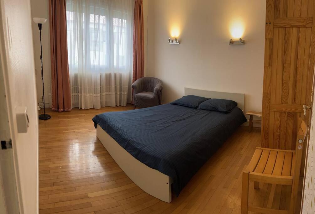 - une chambre avec un lit et une chaise dans l'établissement Villa Seine, à Bezons