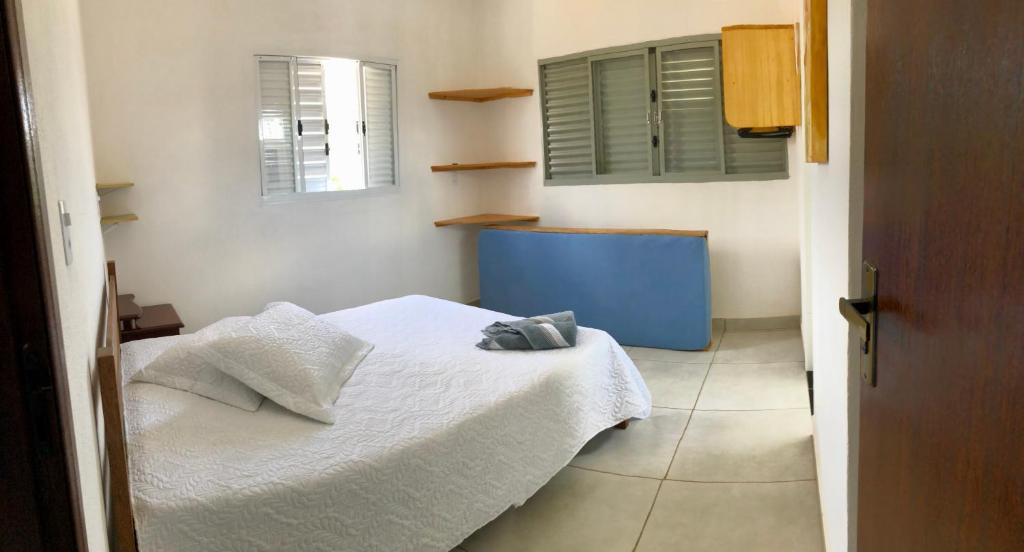 a small bedroom with a white bed and a window at Serra da Canastra - Casa em Vargem Bonita/MG in Vargem Bonita