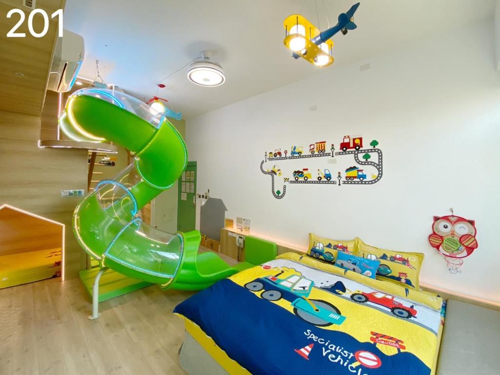 a childs room with a green slide and a bed at Wind Natural Parent-child Inn in Houli