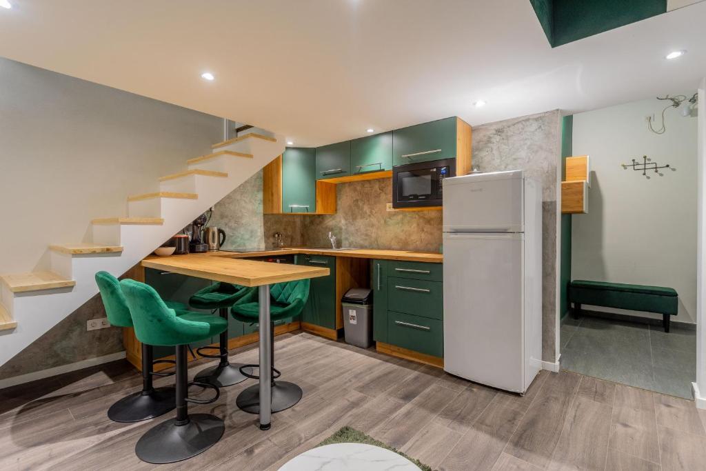 a kitchen with green cabinets and a table and a refrigerator at Full equipment designed apartment in the heart of Budapest for 4 people in Budapest