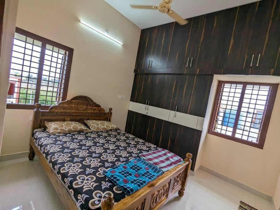 um quarto com uma cama num quarto com armários de madeira em Jo's Homestay em Tiruvannāmalai