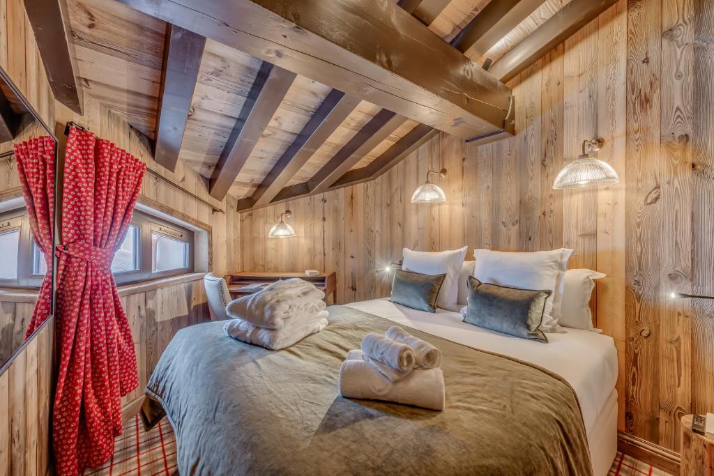 a bedroom with a bed in a wooden cabin at Hotel & Spa Le Val d'Isère in Val-d'Isère