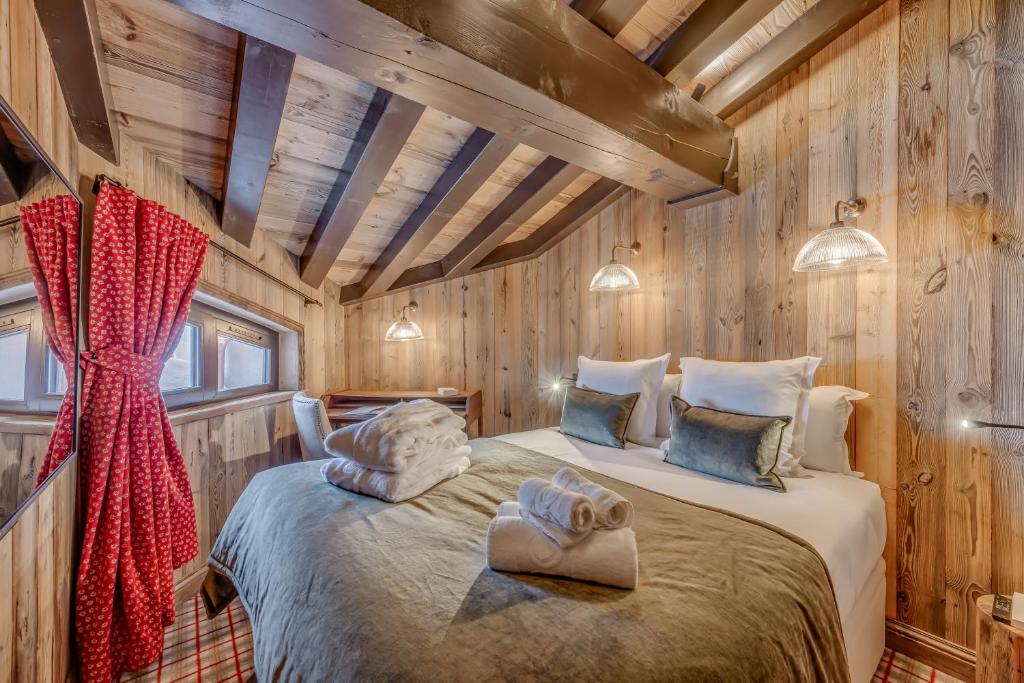 a bedroom with a bed in a wooden cabin at HOTEL LE VAL D&#39;ISERE in Val-d&#39;Isère