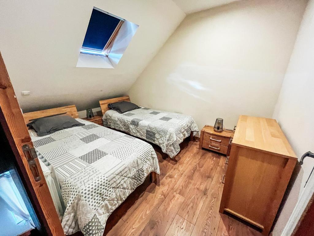 1 dormitorio con 2 camas y ventana en Les Glycines, en Guewenheim