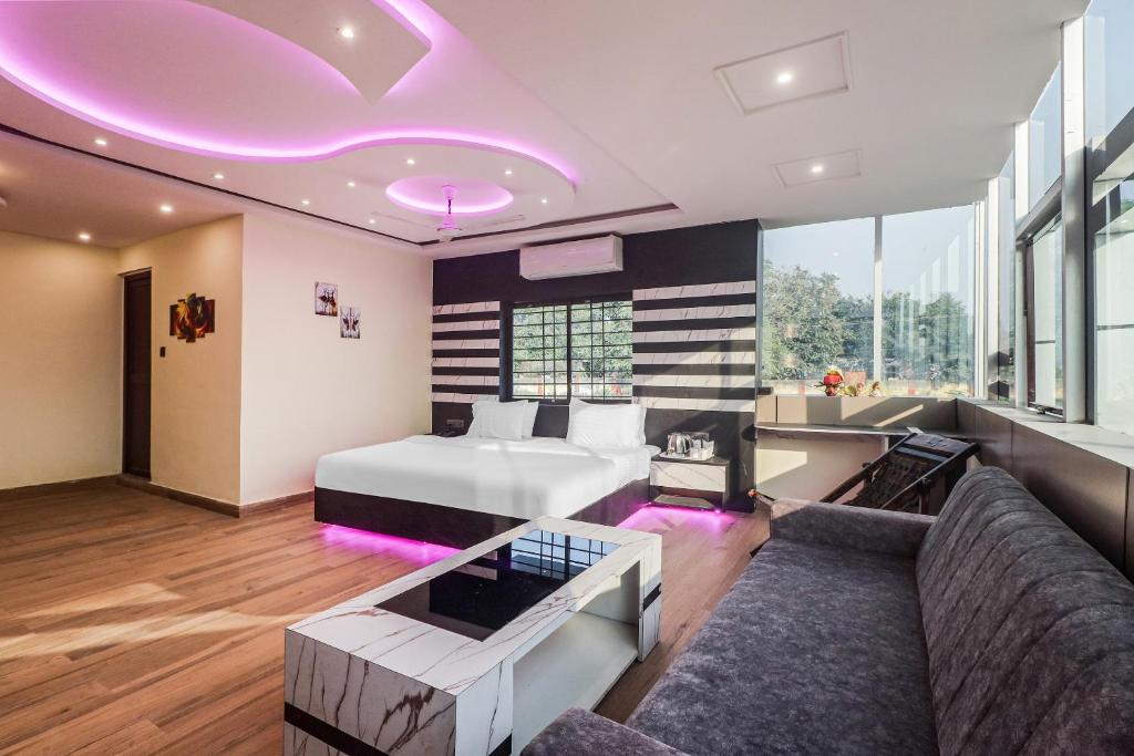 een woonkamer met een bed en een bank bij Hotel Hirak Inn in Dhanbad