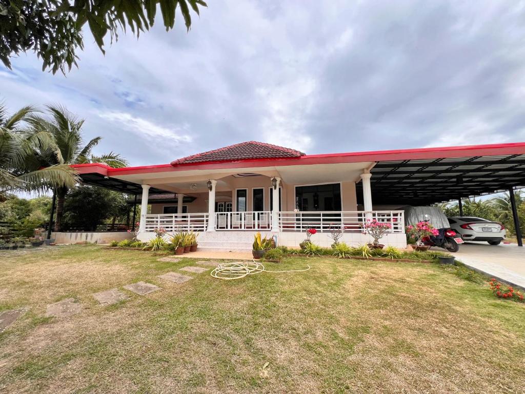 a white house with a red roof at เสริมสุขฟาร์มแอนด์โฮมสเตย์ จันทรบุรี in Tha Mai