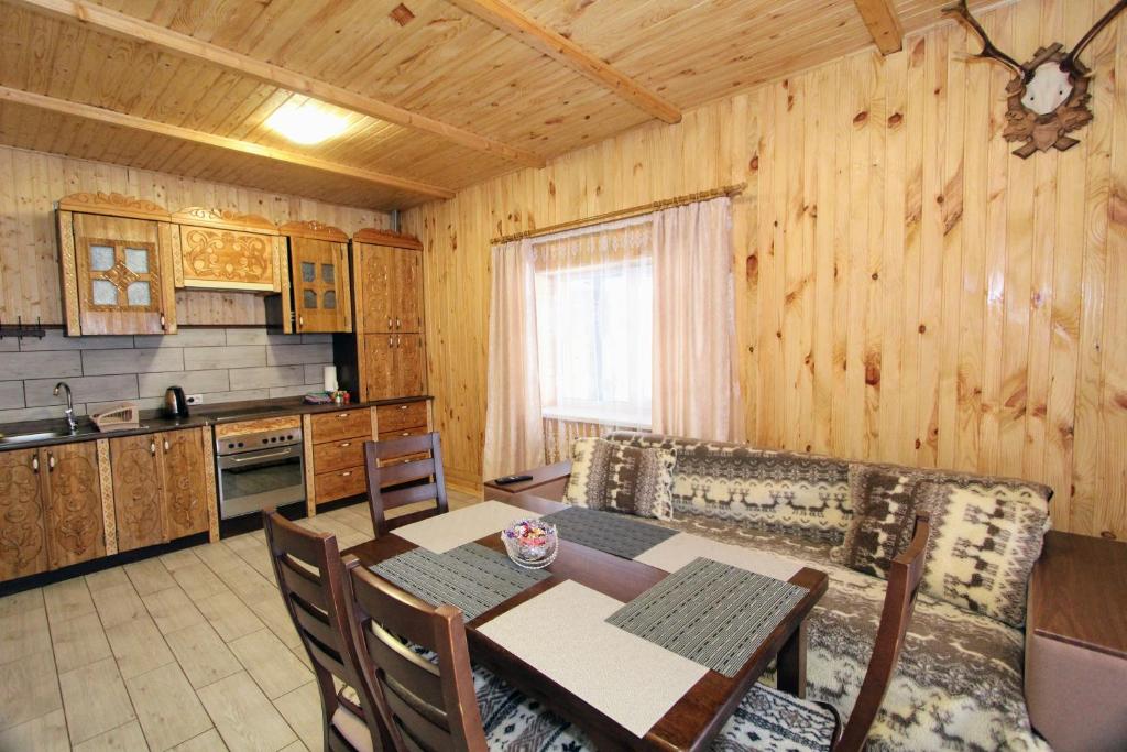 a kitchen and dining room with a table and chairs at Котедж "На Дачній" in Yaremche