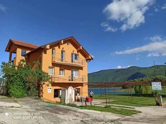 ein großes Haus mit Bergen im Hintergrund in der Unterkunft Apartmani Šćit 