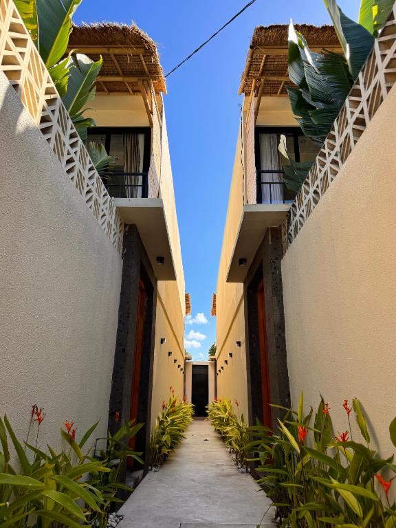 een steeg tussen twee gebouwen met planten bij Villa de Mer Bali in Legian