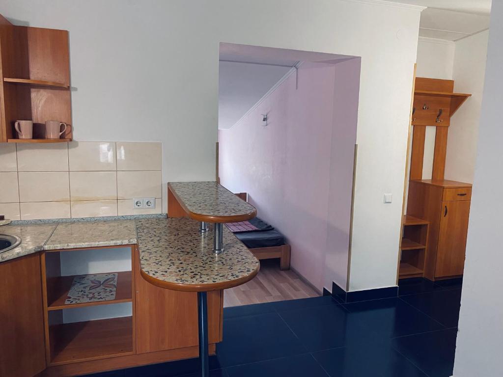 a kitchen with a counter and two stools in it at Hostel Serge in Lviv