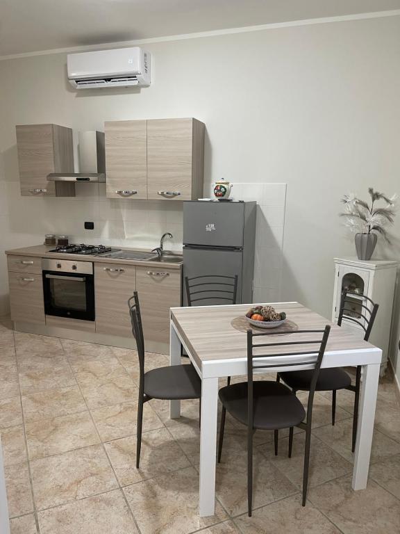een keuken met een witte tafel en stoelen bij casa stefano 