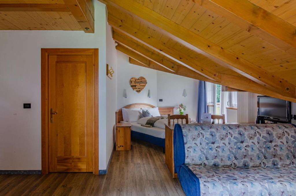 1 dormitorio con 1 cama y 1 sofá en una habitación en Hotel Bella di Bosco, en Malè