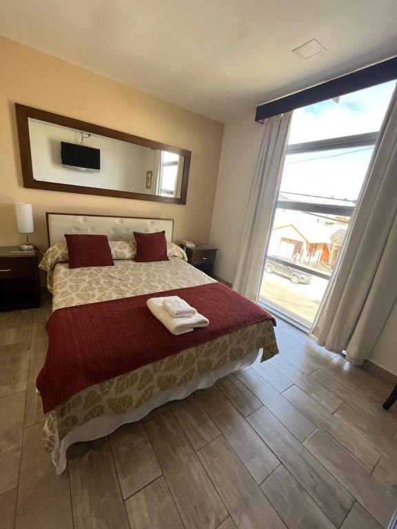 a bedroom with a large bed and a large window at Gran Hotel Laserre in Río Grande