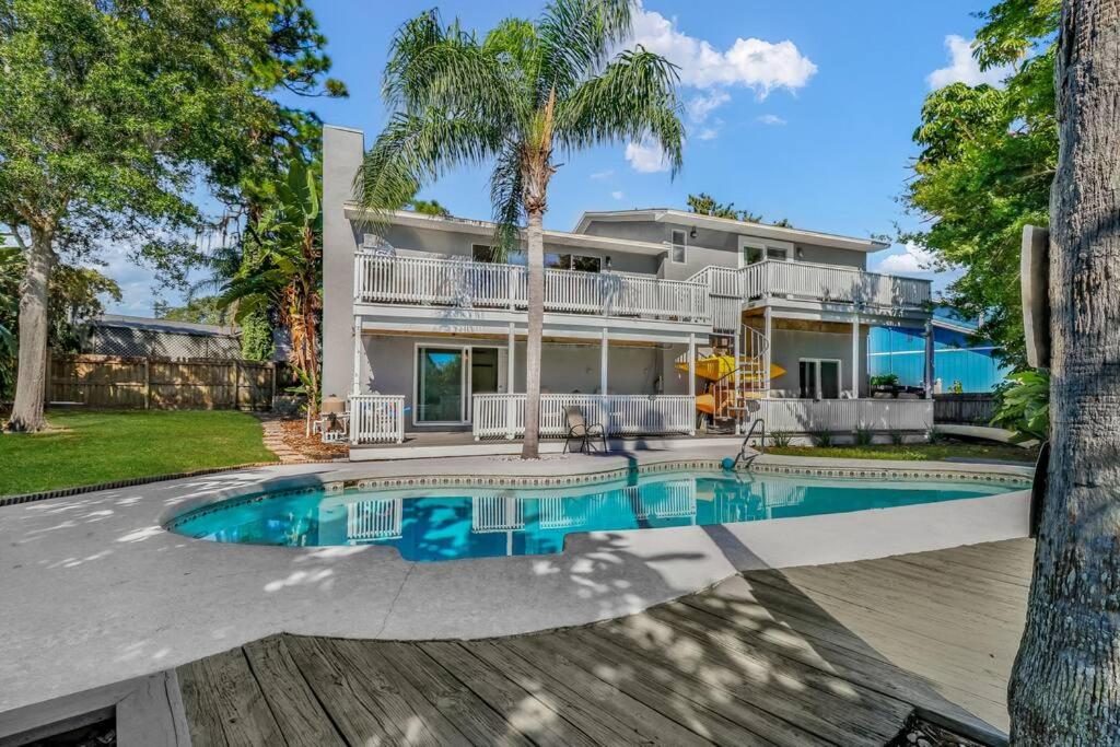una casa grande con piscina frente a ella en Florida Life on the Water. Heated Pool, fishing, kayaks, gameroom en Palm Harbor