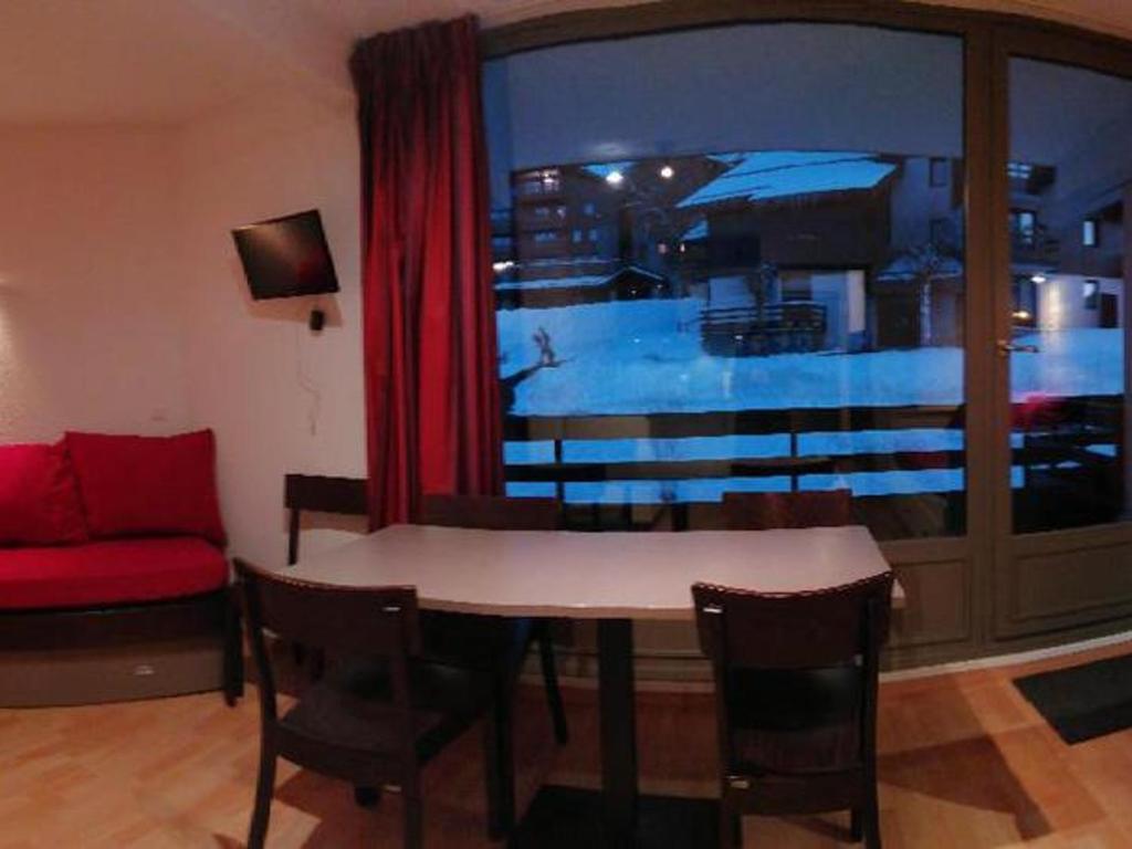 a living room with a table and a red couch at Studio La Plagne Montalbert , 1 pièce, 5 personnes - FR-1-181-2468 in Aime-La Plagne