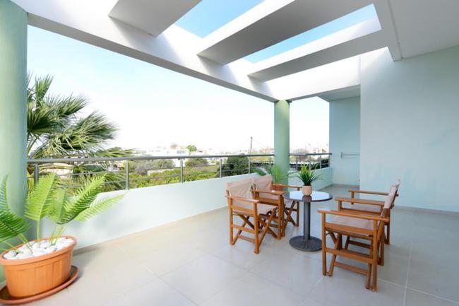 een balkon met stoelen en een tafel met uitzicht bij Elli Garden View - Spacious Fully Equipped Apartment in Kremasti