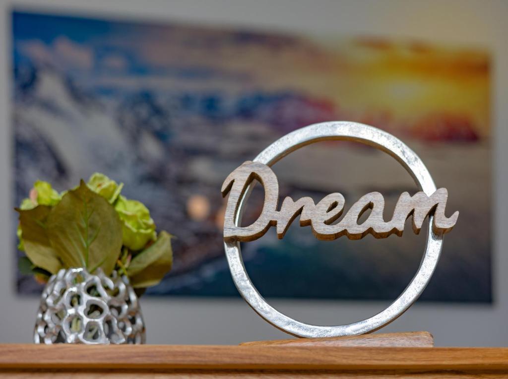 een metalen teken dat zegt droom naast een vaas bij SweetHome - Poing Apartments in Poing