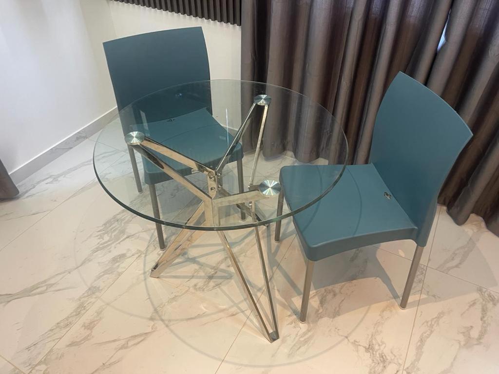 uma mesa de vidro e duas cadeiras sentadas uma ao lado da outra em White Garden Hotel em Maputo