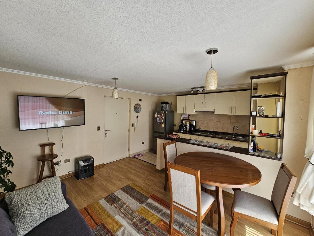 ein Wohnzimmer mit einem Tisch und einer Küche in der Unterkunft Apartamento full equipado in Temuco