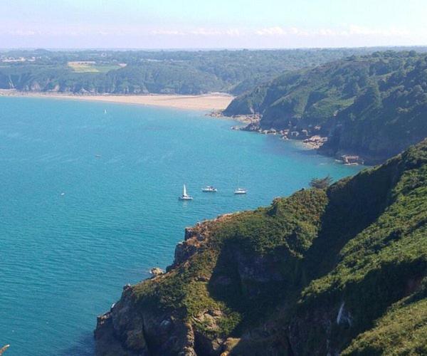 two boats in a large body of water with a beach at La Suite 27 bis, duplex indépendant in Guingamp