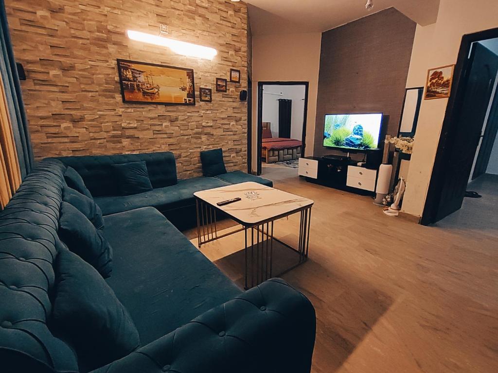 a living room with a blue couch and a table at APARTMENTS of Comfort! in Islamabad