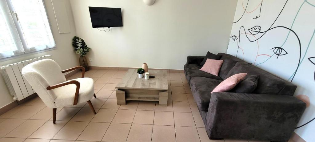 uma sala de estar com um sofá preto e uma mesa em T3 “Groix“- 50 m de la plage de Fort Bloqué/Ploemeur em Ploemeur