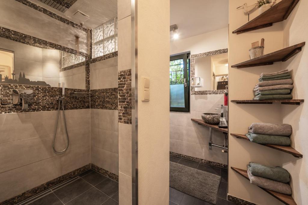 a bathroom with a walk in shower and a glass door at Boutique Apartments Benz I-III in Bergisch Gladbach