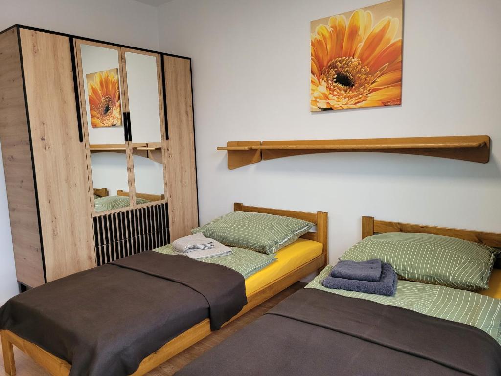 two beds in a room with a mirror at Apartmán Senica in Senica