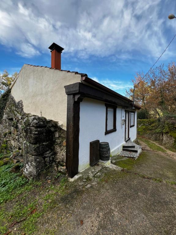 a small white house with a chimney on top of it at Sola Costeiro in Padrenda