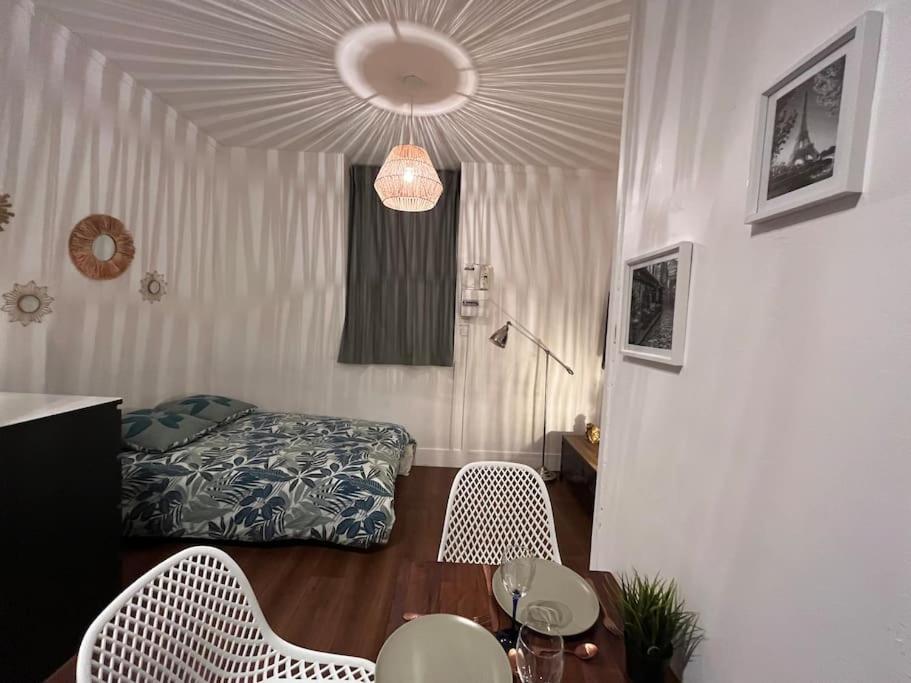 een kamer met een bed en een tafel en stoelen bij Studio cosy parking gratuit et à 5 minutes gare in Le Plessis-Bouchard