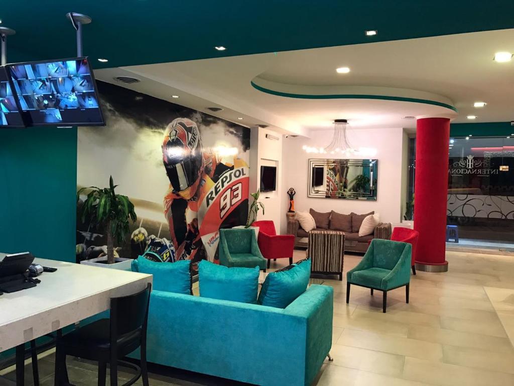 salon z niebieską kanapą i zielonymi krzesłami w obiekcie Hotel internacional w mieście Termas de Río Hondo