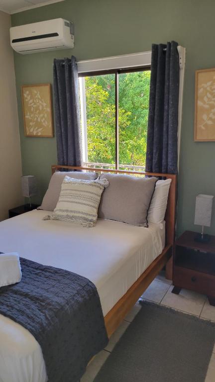 a bedroom with a large bed with a window at Henko House in Quepos