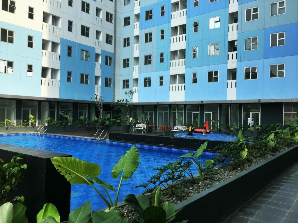 an apartment building with a swimming pool in front of it at Urbantown Serpong in Dukuh