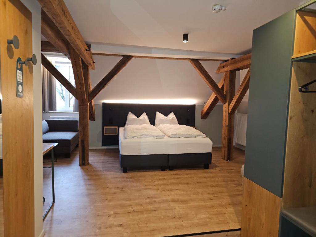 a bedroom with a bed in a room with wooden beams at Hotel Gasthof Stieglers 