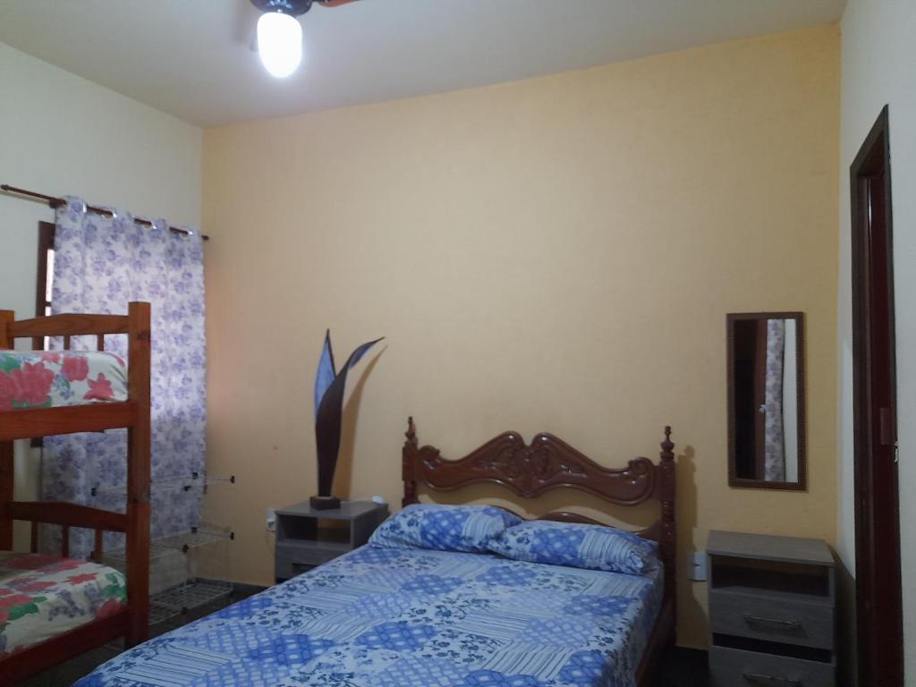 a bedroom with a bed with a blue comforter at Casa em Cabo Frio in Cabo Frio