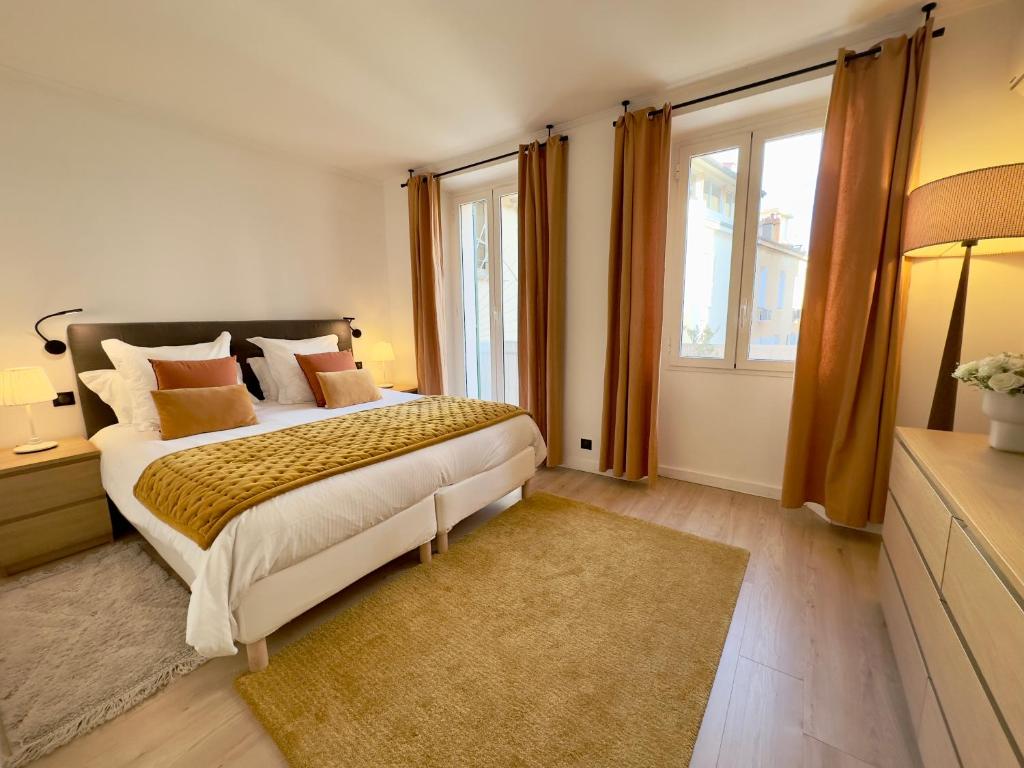 um quarto com uma cama e uma grande janela em Luxueux 3 pièces 80m2 - Espace bureau -1mn Beach Croisette em Cannes