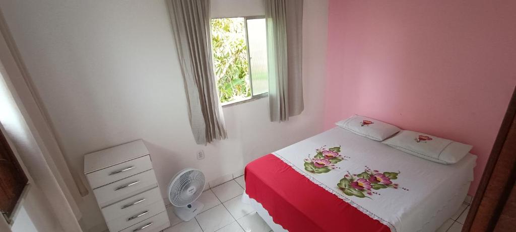 um pequeno quarto com uma cama vermelha e branca e uma janela em Casa 2/4 em Itacimirim - Beira do Rio Pojuca em Camaçari